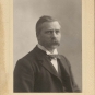 Photographie noir et blanc d'un homme portant complet et moustachu