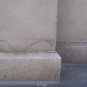 Photographie couleur d’une dalle de roche grise à la base de la colonne d’un édifice