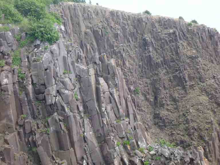 Colour photograph of a gray rock cliff