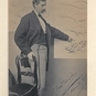 Photographie noir et blanc d’un homme debout qui désigne du doigt un dessin au mur