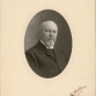 Black and white photograph of a man in a suite in an oval frame