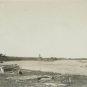 Black and white photograph of a beach on the ocean with trees
